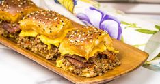 two cheeseburger sliders on a wooden platter