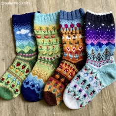 five pairs of colorful knitted socks sitting on top of a wooden floor next to each other