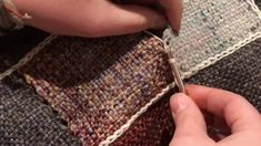 someone is stitching fabric with scissors on a piece of material that looks like woven cloth