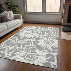 a living room with a large rug on the floor next to a couch and fireplace