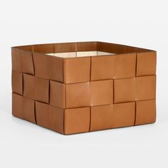 a brown leather basket that is made out of squares and rectangles on the sides