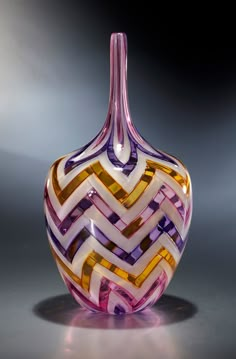 a colorful glass vase sitting on top of a table