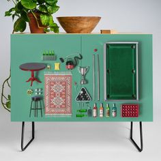 a green cabinet with various items on it and a potted plant in the background