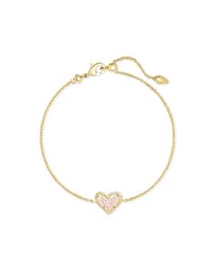 Wear your heart on your wrist with the Ari Heart Gold Chain Bracelet in Iridescent Drusy. This asymmetrical design shines solo, but functions just as well as part of your everyday stack. Metal 14k Yellow Gold Over Brass Material Iridescent Drusy Closure Adjustable lobster claw Size 0.56” L x 0.37” W station, 7.5” L circumference Please note: Due to the one-of-a-kind nature of the medium, exact colors and patterns may vary slightly from the image shown. | Kendra Scott Ari Heart Gold Chain Bracelet in Iridescent | Drusy Expensive Outfits, Kendra Scott Bracelet, Gold Chain Bracelet, Rose Gold Quartz, Family Jewels, Heart Chain, Gold Bracelet Chain, Kendra Scott Jewelry, Asymmetrical Design