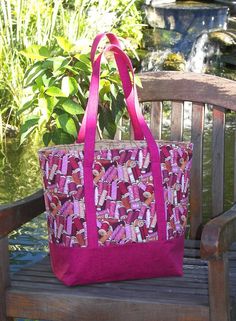 a pink tote bag sitting on top of a wooden bench next to a pond