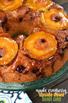 a pineapple upside down bundt cake on a glass platter with the words apple cranberry upside down