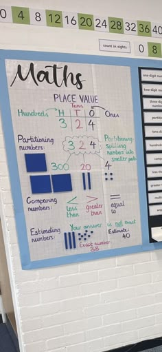 a bulletin board with numbers and place value on it next to a bench in front of a brick wall