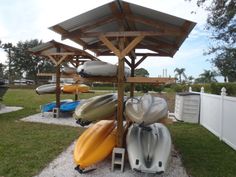 several canoes and kayaks are on display under an umbrella in the backyard area