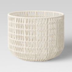 a white basket that is sitting on the ground