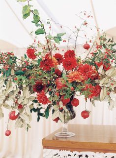 a vase filled with red flowers on top of a table