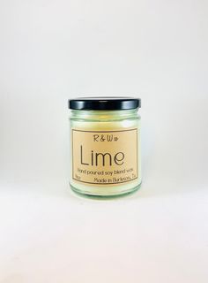 a jar of lime scented soy candle on a white background