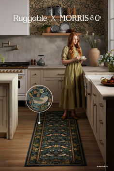 a woman standing in a kitchen next to a rug