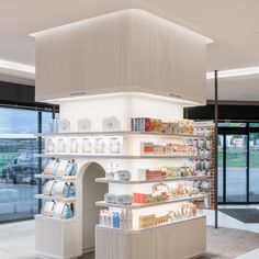 the inside of a store with many items on shelves and in front of large windows