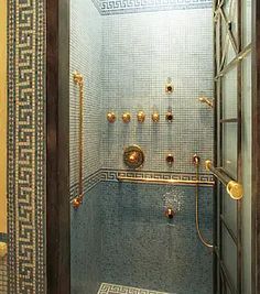 a bathroom with a glass shower door and tiled walls in the shower area is shown