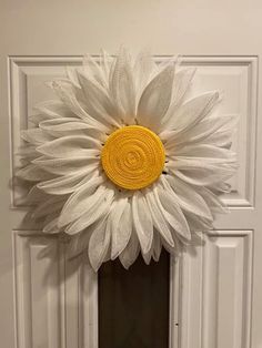 a white door with a yellow flower on the top and bottom part, in front of it