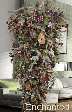 a birdhouse is decorated with flowers and leaves in the shape of a tree trunk