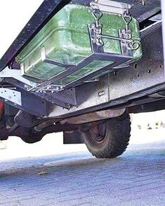 the back end of a truck with luggage strapped to it