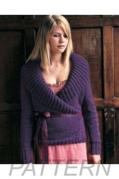 a woman standing in front of a wooden door wearing a purple sweater and pink skirt