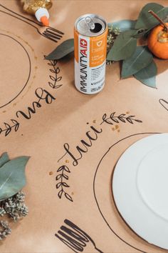 a can of orange juice sitting on top of a table next to a white plate