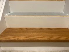 a close up of some steps with wood on the bottom and bottom part in white paint