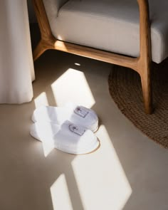 two towels are laying on the floor next to a chair and armrests in front of a window