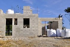 a house under construction with cement bags in the foreground