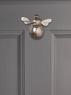 a door with a metal bee decoration on it's side and the top part of its head