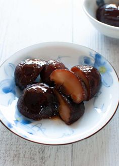 some food is sitting on a blue and white plate with sauce in the bowl next to it