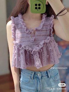 a doll is taking a selfie with her cell phone while wearing a crocheted top