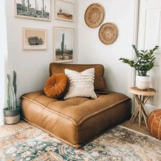 a living room filled with lots of pictures on the wall and a brown leather couch