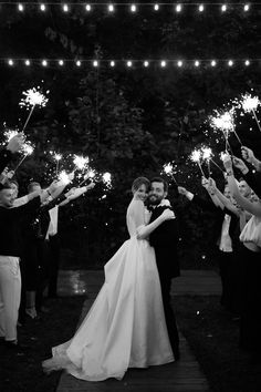 a bride and groom are surrounded by sparklers