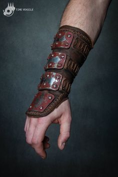 a man's arm covered in metal and leather