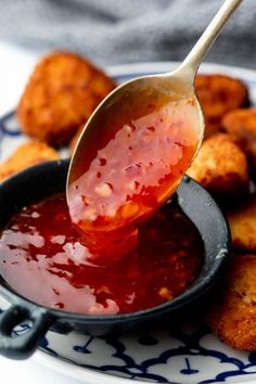 a spoon full of ketchup sitting on top of some fried food