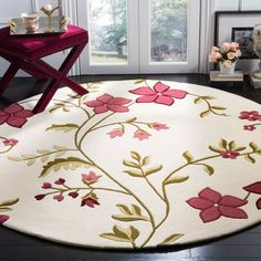 a white rug with red flowers on it in front of a window and table next to the door