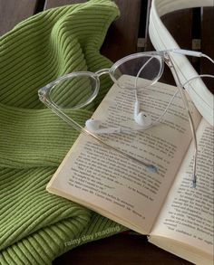 an open book with glasses on top of it