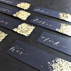 black and gold place cards with glitter on them