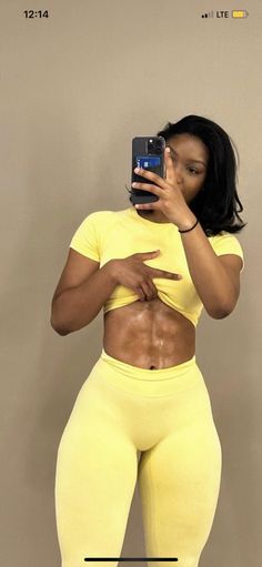 a woman taking a selfie with her cell phone while wearing yellow leggings