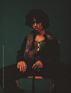 a man with dreadlocks sitting in a chair