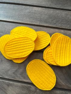 four yellow waffles sitting on top of a wooden table next to each other