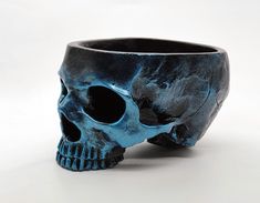 a blue and black skull vase sitting on top of a table