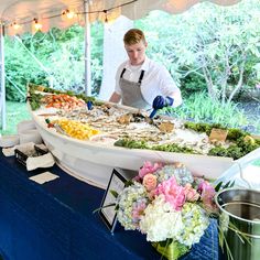 a man standing in front of a table filled with food