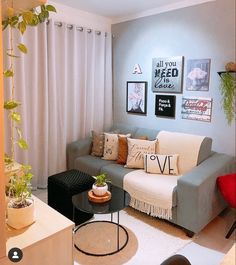 a living room filled with furniture and pictures hanging on the wall above it's windows