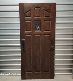 a wooden door in front of a metal wall