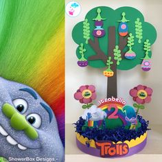 there is a cake decorated like a tree and an image of a troll's head