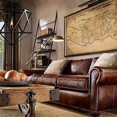 a living room filled with furniture and a map hanging on the wall above it's coffee table