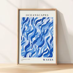 an ocean scene with waves in blue and white, framed on a wooden shelf next to a wall