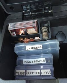 the inside of a car with three plastic containers containing coins and other items