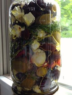 a glass jar filled with food sitting on top of a window sill