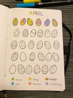 an open notebook with easter eggs drawn on it and colored pencils next to it