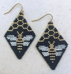 two pairs of earrings made out of black, white and gold seed bead beads